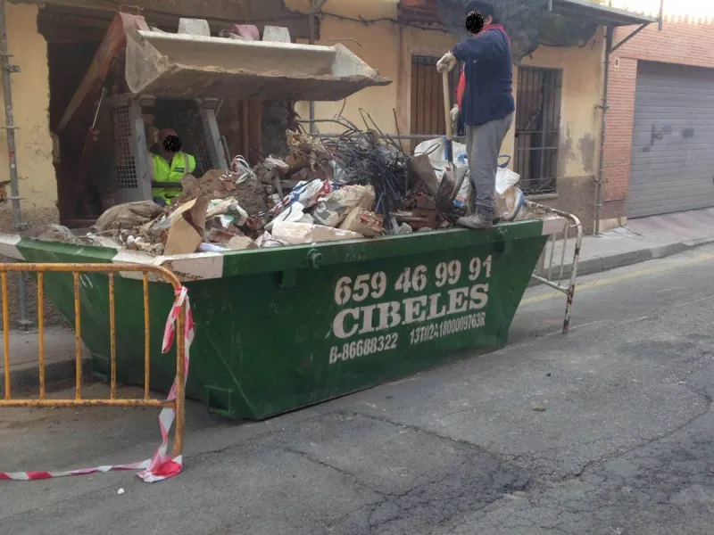 Contenedor de obra lleno de escombro en una reforma